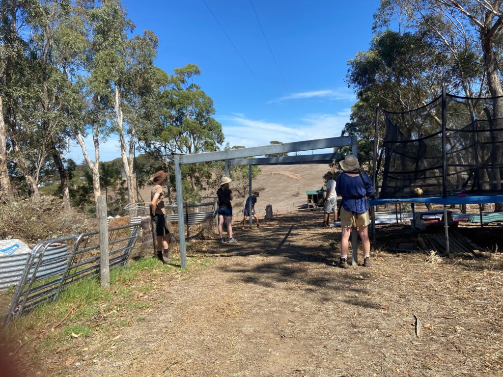 People moving a shed frame from one paddock to another