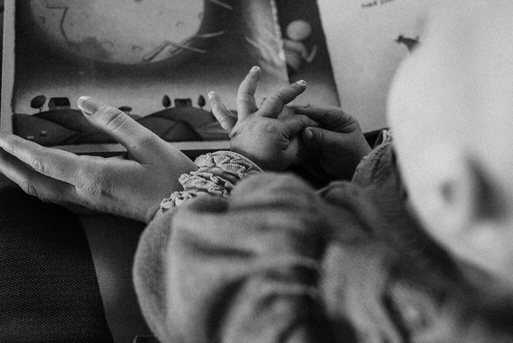 Black and white photo of a baby reading a book