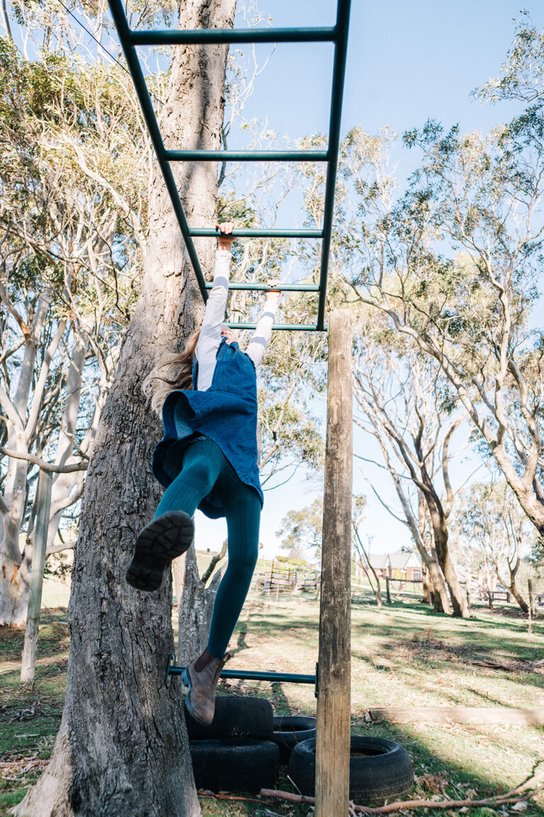 Girl swinging on monkey bars