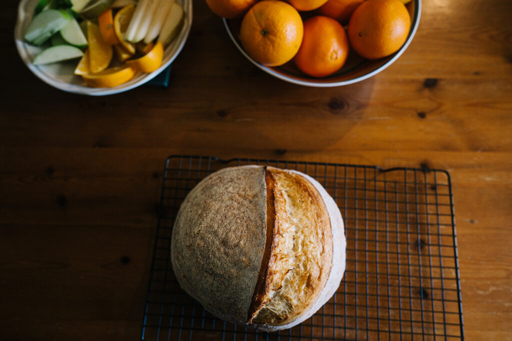 Photo of a loaf of sourdough and fruit bowls
