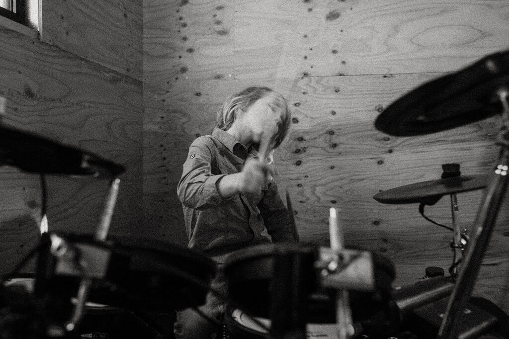 Child playing drums with face blurred